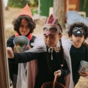 children trick or treating in different costumes knocking on a door