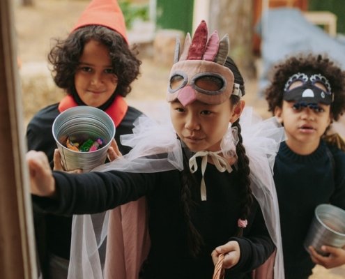 children trick or treating in different costumes knocking on a door