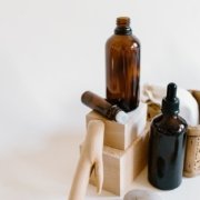 peppermint oil bottles next to other tan and wood care items on white background